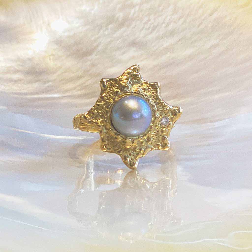 18k gold pearl ring with an ocean inspired textured surface with a small white diamond. Handcrafted fine jewelry by Jane Bartel Jewelry