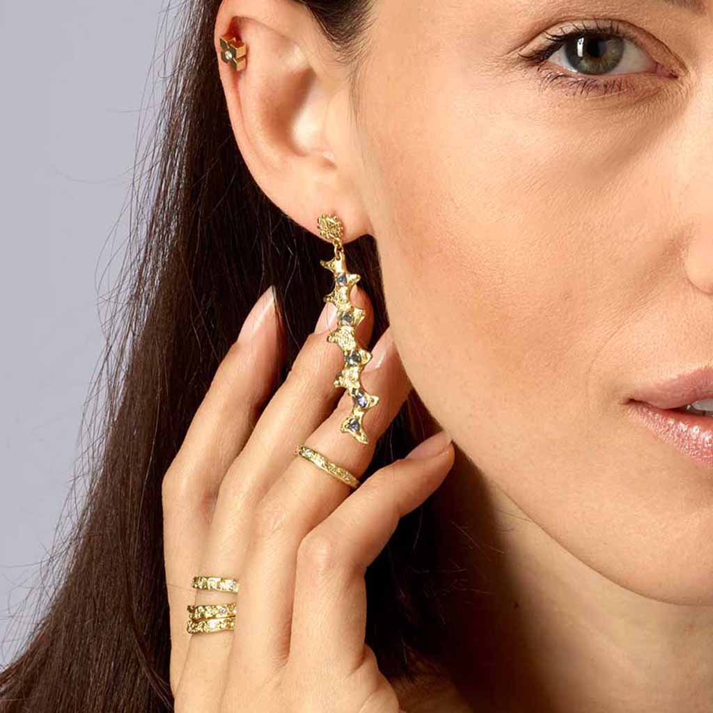 woman wearing 18k long gold sapphire earrings
