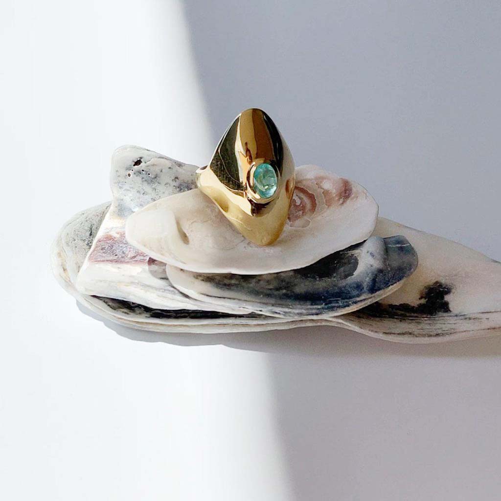 18k gold paraiba tourmaline ring showcased with natural seashellsby Jane Bartel Jewelry