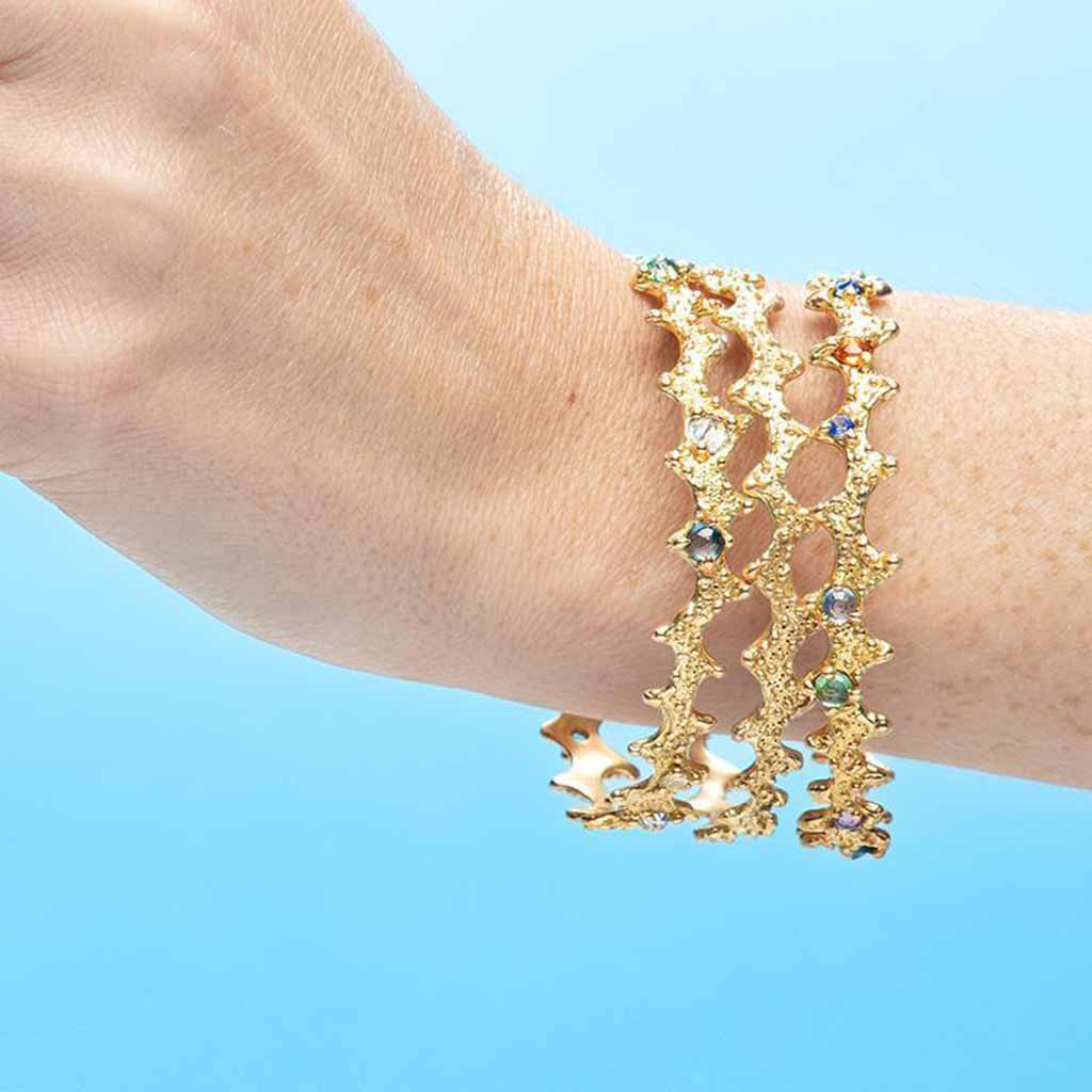 18k gold multi-colored sapphire bangle bracelets with texture inspired by a sea urchin sea shell. Ocean inspired jewelry by Jane Bartel