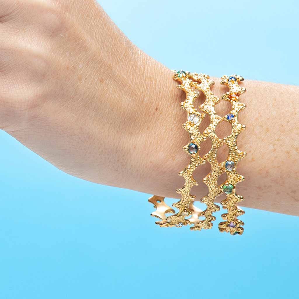 Handcrafted 18k solid gold bangle bracelet with texture inspired by a sea urchin shell. Ocean inspired jewelry by Jane Bartel